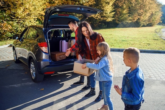 A close-up of a family happily unpacking groceries from the trunk of a brand new electric SUV in their driveway, showcasing the practical benefits of owning an EV in a suburban setting.