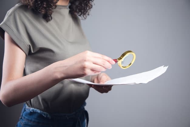 A close-up shot of a hand holding a magnifying glass over a document with financial figures, emphasizing the detailed search process for unclaimed property.