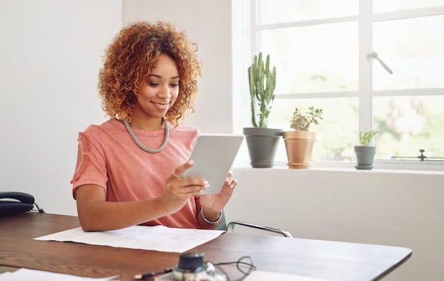 A person sitting at a desk, smiling while talking on the phone and pointing at a tablet showing utility bill options. The setting is a bright, modern home office.