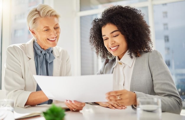 A financial advisor sitting at a desk, reviewing documents with a client, both smiling and engaged in discussion about charitable giving options.